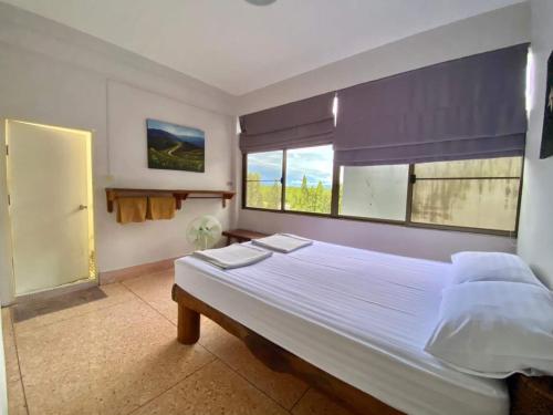 Un dormitorio con una cama grande y una ventana en No7 Guesthouse, en Krabi