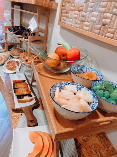 a table with bowls of fruit and plates of food at Hotel do Mercado in Aveiro