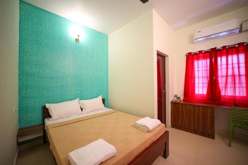 a bedroom with a bed and a red window at VR Inn , 900 Meters from Rock Beach in Pondicherry