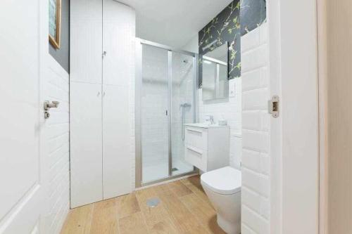 een witte badkamer met een toilet en een douche bij Casa Angeline Rosa 2 By KubiK in Cáceres