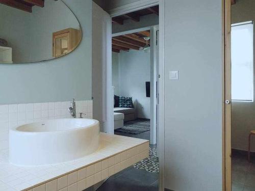 baño con lavabo blanco grande y espejo en Casa cerca de la playa Casa da Cuncheira, en Carnota