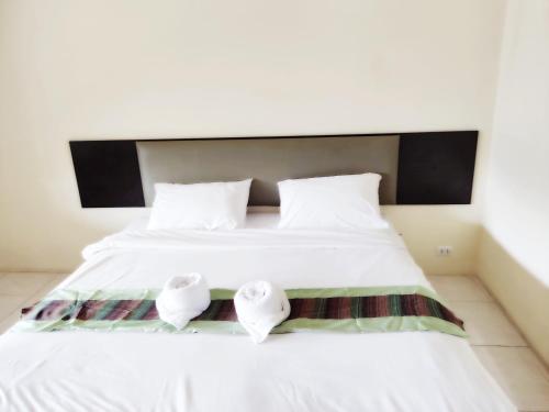 a bed with two pillows and two towels on it at Laemdin Hotel in Koh Samui 