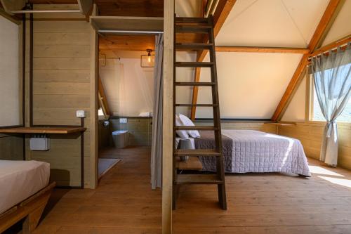 una scala in una camera con un letto e una camera da letto di Il Castagno Toscana Glamping a Campiglia Marittima