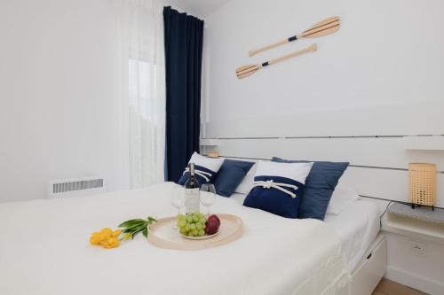 a white bed with a plate of fruit on it at Seaside Apartment Wybrzeze Dziwnow in Dziwnów
