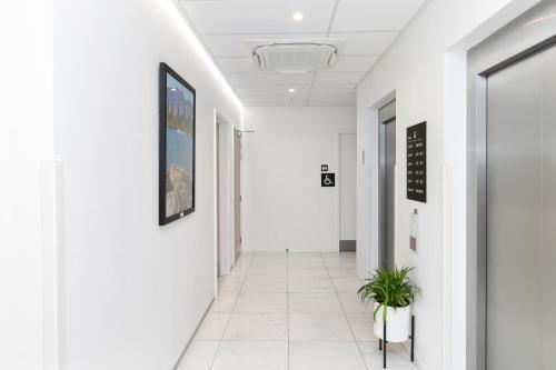 a corridor of an office building with white walls and a white hallway at Christchurch City Hotel in Christchurch