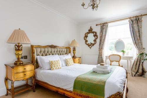 a bedroom with a bed and a table and a window at The Retreat New Forest, Hinton in Christchurch