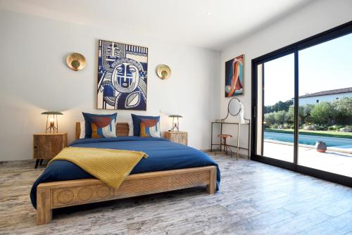 une chambre avec un grand lit et une grande fenêtre dans l'établissement Villa Hameau de Signargues, entre Avignon - Pont du Gard et Uzes, à Domazan