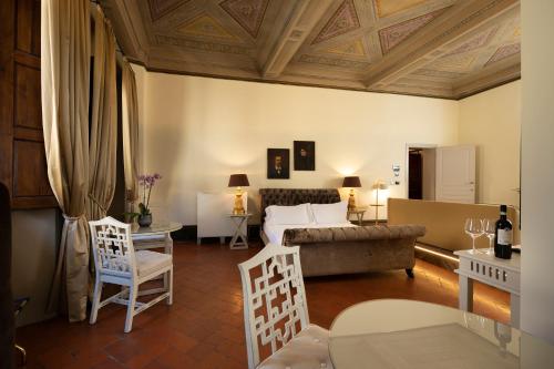 a living room with a couch and a table and chairs at Palazzo Martellini Residenza d'epoca in Florence
