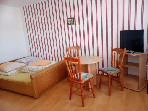 a small bedroom with a bed and a table and chairs at Pokoje Gościnne Tomasz in Międzywodzie