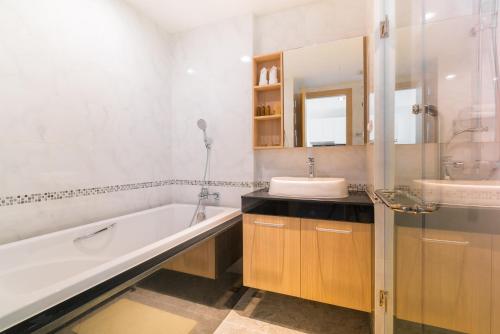 uma casa de banho branca com uma banheira e um lavatório em Grand Kata VIP - Kata Beach em Kata Beach