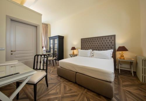 a bedroom with a bed and a desk and a piano at Palazzo Martellini Residenza d'epoca in Florence