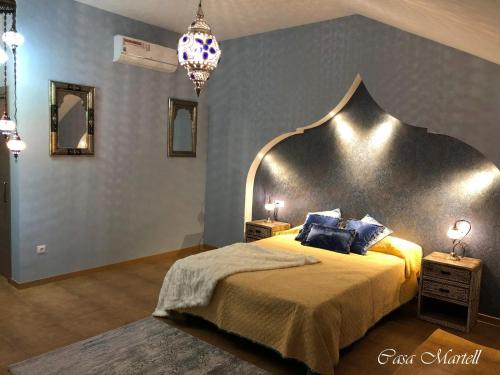 a bedroom with a large bed with a large headboard at Hospedería Casa Martell in Daroca