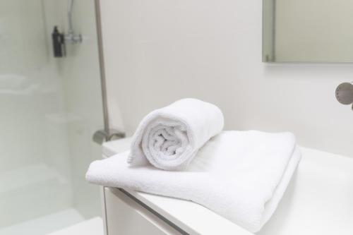 una pila de toallas en un mostrador en el baño en Hostel Villa Miguela, en Santander