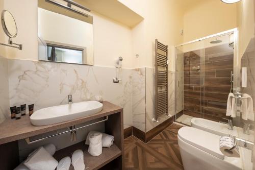 a bathroom with a sink and a toilet and a tub at Palazzo Martellini Residenza d'epoca in Florence