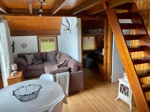 a living room with a couch and a table at Loch Aweside Forest Cabins in Dalavich