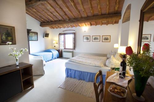 a bedroom with a bed and a table in a room at Il Rosolaccio in San Gimignano