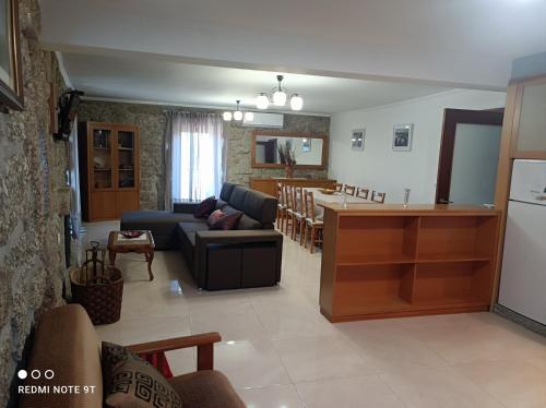 uma sala de estar e cozinha com um sofá e uma mesa em Casa Sambinho Gerês em Rio Caldo