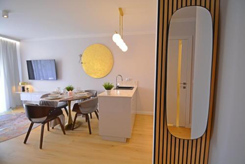 a kitchen and a dining room with a mirror at Sun Towers - Apartamenty Bryza - Apartamenty z parkingiem in Świnoujście