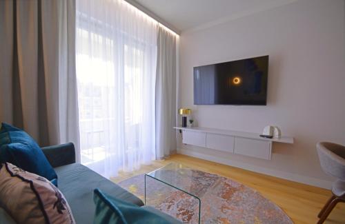a living room with a couch and a glass coffee table at Sun Towers - Apartamenty Bryza - Apartamenty z parkingiem in Świnoujście