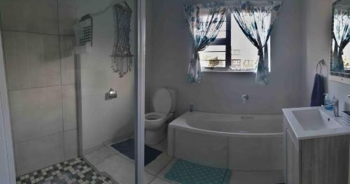 La salle de bains est pourvue d'une baignoire, de toilettes et d'un lavabo. dans l'établissement Black Rock Haven, à Scottburgh