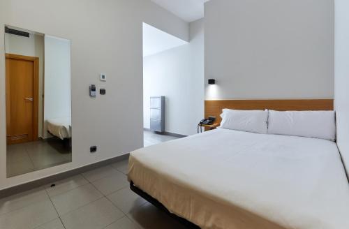 a bedroom with a large white bed and a mirror at Olarain in Donostia-San Sebastián