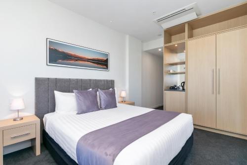 a bedroom with a large bed and a cabinet at Christchurch City Hotel in Christchurch