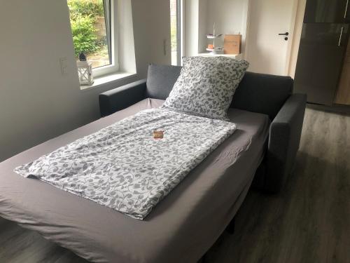 ein Bett mit einer Decke auf dem Zimmer in der Unterkunft Ferienwohnung Marli in Marburg an der Lahn