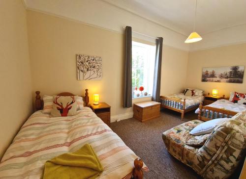 - une chambre avec 2 lits, un canapé et une fenêtre dans l'établissement East Wing Apartment in Elgin, à Elgin