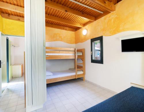 a room with bunk beds and a flat screen tv at Residence Mare Pineta in Casal Borsetti