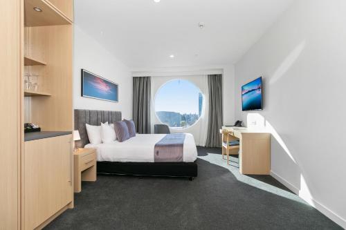 a hotel room with a bed and a desk at Christchurch City Hotel in Christchurch