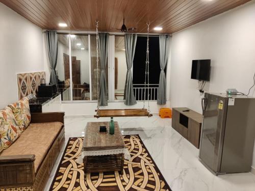 a living room with a couch and a table at WhiteHouse Homestay by Oxystays Hospitality in Alibaug