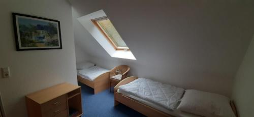 ツィングストにあるAm Deich 36のベッド2台と窓が備わる小さな客室です。