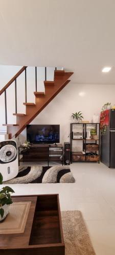 a living room with a staircase and a living room with rugs at Yuna Homestay - Furnished Home in Butuan in Butuan