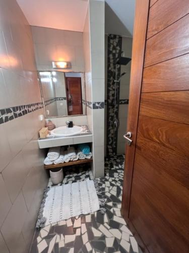 baño con lavabo, espejo y puerta en Villa ALDIANA, en Cap Skirring