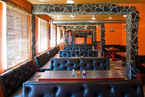 a dining room with leather chairs and a table in the middle at Horský Hotel Podjavorník in Papradno