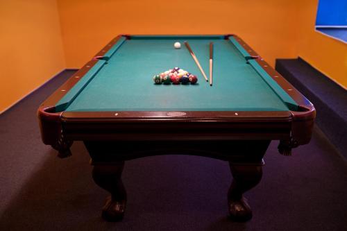 a pool table with a ball and two cue sticks at Horský Hotel Podjavorník in Papradno