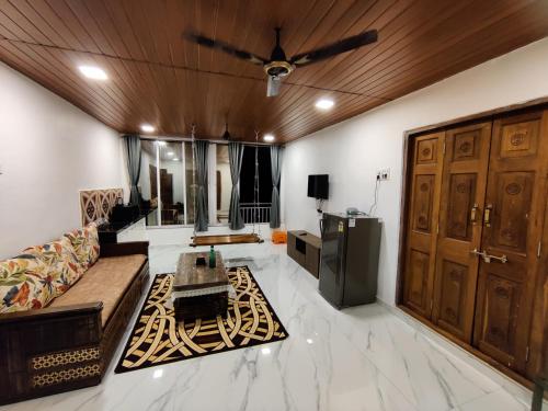 a living room with a couch and a ceiling fan at WhiteHouse Homestay by Oxystays Hospitality in Alibaug