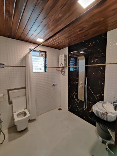 a bathroom with a toilet and a sink at WhiteHouse Homestay by Oxystays Hospitality in Alibaug
