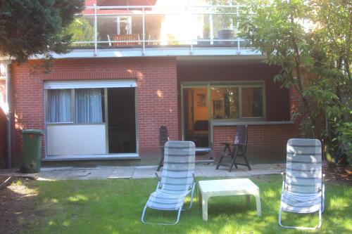a group of chairs and a table in a yard at B&B Middelheim in Antwerp