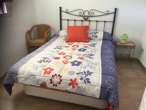 a bedroom with a bed with a flowery comforter at Vista al Mar Ylenia in Almería