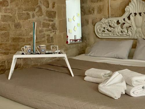 um quarto com uma cama e uma mesa com toalhas em B&B Casa AMALIA em Barletta