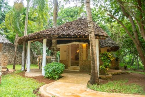 a small house with a thatch roof at Eleven Pearl Boutique Hotel & Spa in Diani Beach