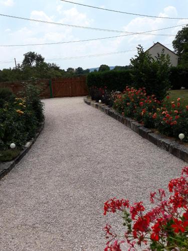 a gravel driveway with flowers in a garden at La Roulotte de Bourgogne in Brianny