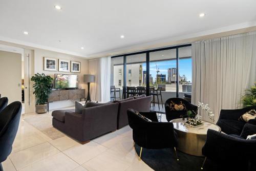 a living room with couches and a table at Aria Apartments in Gold Coast