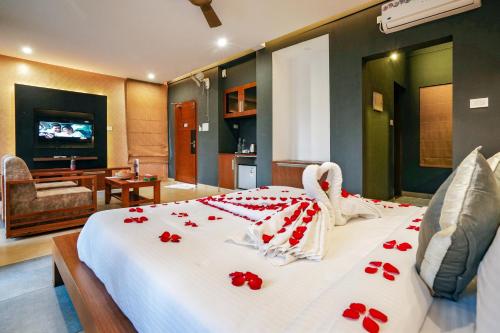 a bedroom with a bed with red roses on it at Kuruva Island Resort And Spa - By KABINI BREEZE in Mananthavady