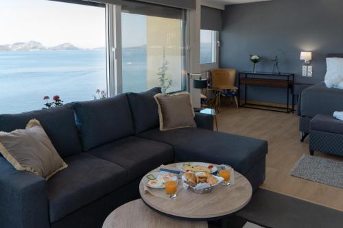 a living room with a blue couch and a table at Karalis City Hotel in Pylos
