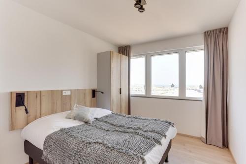 a bedroom with a bed and a large window at Evancy La Marina Boulogne-sur-Mer in Boulogne-sur-Mer