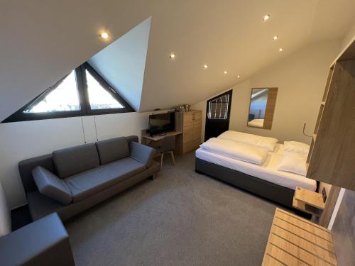 a bedroom with a bed and a couch and a window at Hotel Am Tiergarten in Nürburg