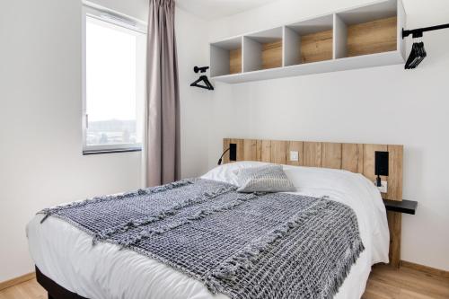 a bedroom with a bed with a wooden headboard at Evancy La Marina Boulogne-sur-Mer in Boulogne-sur-Mer