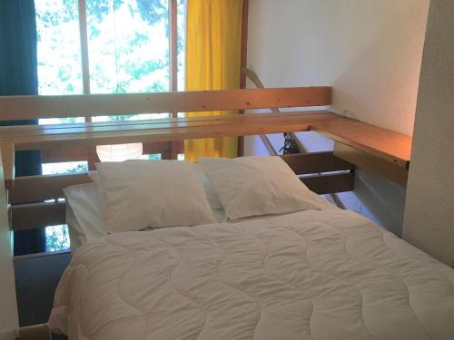 - un lit dans une chambre à côté d'une fenêtre dans l'établissement Duplex tranquille · Proche des pistes · Balcon · WiFi · Parking - FR-1-346-430, à Arc 1800